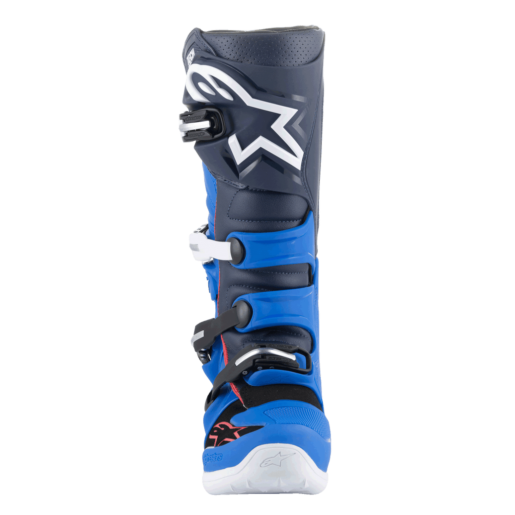 Buty Alpinestars Tech 7, buty motocrossowe, kolor Alpine Blue, Night Navy i Bright Red, widok z przodu przedstawiający granatową cholewkę z dużym białym logo Astars, jasnoniebieskie panele ochronne TPU oraz system zapięcia na klamry, wysokiej klasy obuwie do jazdy terenowej.