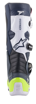 Buty Alpinestars Tech 7, buty motocrossowe, widok z tyłu, kolorystyka granatowa, biała i ciemnoszara z jaskrawożółtym neonowym ochraniaczem pięty, harmonijkowe strefy zgięcia, branding Tech Series
