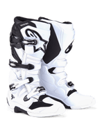 Buty Alpinestars Tech 7, buty motocrossowe, biało-czarne, system zapięcia na cztery klamry ze srebrno-czarnymi elementami, widoczne logo Alpinestars na goleni, wzmocnione panele TPU dla ochrony w terenie.