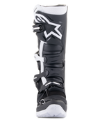 Buty Alpinestars Tech 7 Enduro Drystar®, motocyklowe buty enduro, czarno-białe, z dużym białym logo Alpinestars na nagolenniku, systemem zapięcia na cztery klamry i solidną białą podeszwą, zaprojektowane do jazdy off-road