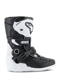 Buty Alpinestars Kids Tech 3S, młodzieżowe buty motocrossowe, biało-czarne, widok z boku prezentujący wysoką cholewkę, system zapięć na klamry i paski, ochronna płyta goleniowa TPU i biała podeszwa, obuwie motocyklowe off-road dla dzieci