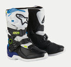 Buty Alpinestars Kids Tech 3S, dziecięce buty motocrossowe, biało-czarno-niebieskie, białe i czarne panele ochronne, niebieskie akcenty na pięcie i u góry, neonowo-żółte logo, bezpieczny system zapięć na klamry