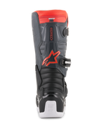 Buty Alpinestars Youth Tech 7S, buty motocrossowe, czarne, ciemnoszare i fluorescencyjne czerwone, widok z tyłu z panelami ochronnymi TPU, czerwonym fluorescencyjnym logo Alpinestars i białymi akcentami na podeszwie, wytrzymałe obuwie ochronne off-road