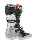 Alpinestars Youth Tech 7S Boots, buty motocrossowe, czarno-srebrno-biało-złote, widok z profilu ze srebrną dolną skorupą, czarno-białymi panelami górnymi, czerwonym akcentem przy górnym mankiecie i systemem zapięcia na trzy klamry