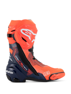 Buty Alpinestars Supertech R Vented MM93 Replica, motocyklowe buty wyścigowe, czerwone fluo i ciemnoniebieskie z czarnymi akcentami, perforowana cholewka z mikrofibry zapewniająca wentylację, białe logo Alpinestars na goleni, numer 93 na czubku.