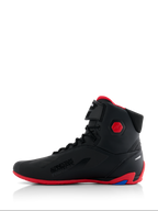 Buty Alpinestars Honda Faster-4, buty motocyklowe, czarno-czerwone, widok z profilu, z jaskrawoczerwoną podeszwą i sześciokątnym ochraniaczem kostki, wysokie sneakersy ze sznurowadłami i paskiem na rzep, branding „Alpinestars Protects”, smukłe obuwie wyczynowe do jazdy szosowej