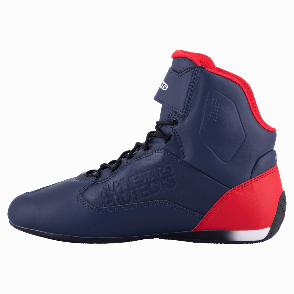 Alpinestars Austin Riding Shoe, Night Navy i Bright Red, widok z profilu prezentujący granatową cholewkę z mikrofibry z czerwonymi akcentami na pięcie i kołnierzu, czarne sznurowadła, wytłoczone logo „Alpinestars Protects”, wysokie buty motocyklowe