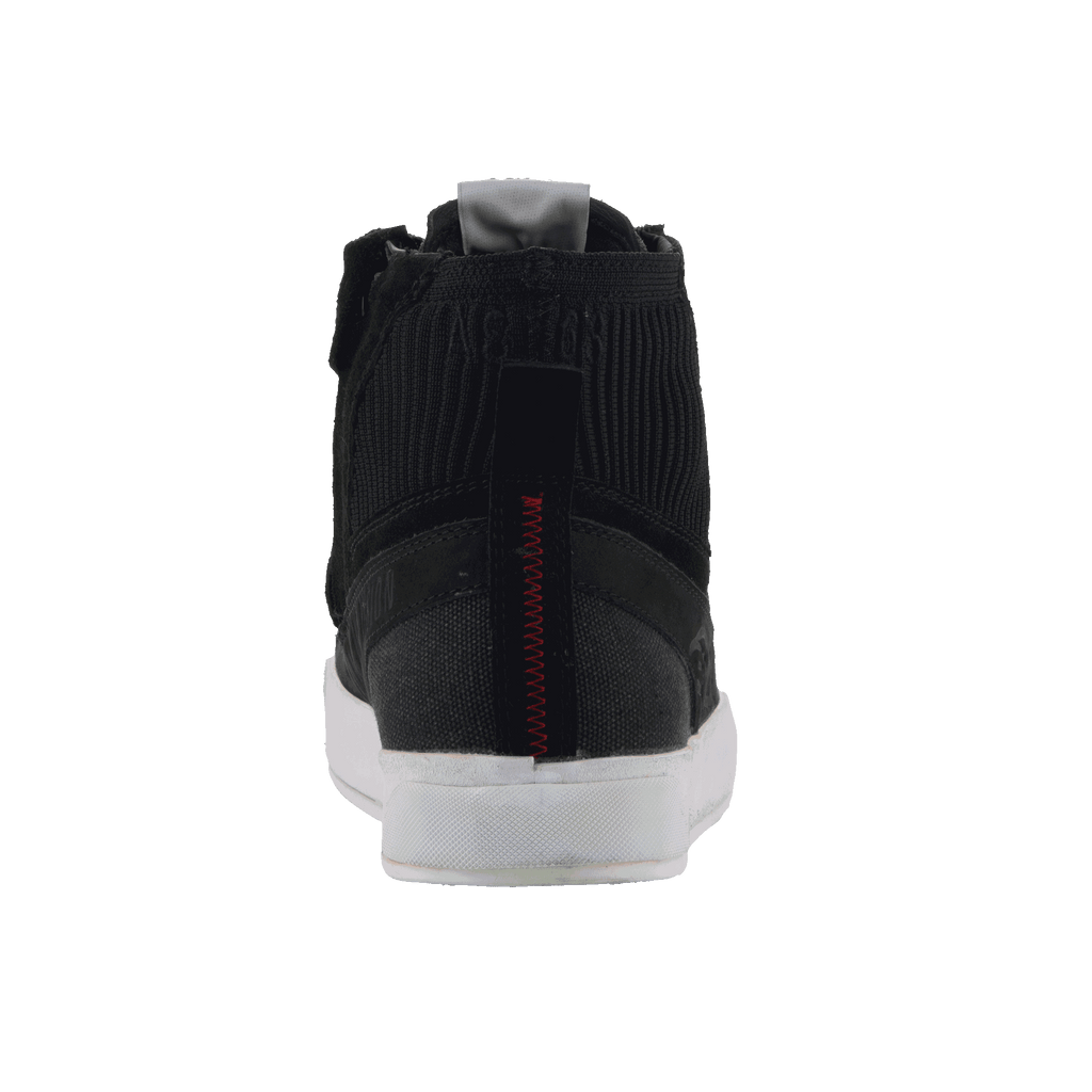 Alpinestars Stated Shoes, Rear View, Black with White Vulcanized Sole, featuring Ribbed Knitted Ankle Collar, Red Zig-Zag Heel Stitching, and Grey Pull Tab, Urban Motorcycle Footwear