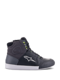 Alpinestars Chrome Drystar Shoes, miejskie sneakersy motocyklowe w kolorze czarnym, ciemnoszarym i żółtym fluo, wykonane z wysokiej jakości skóry i zamszu, biała podeszwa, neonowe żółte sznurowadła i charakterystyczne logo gwiazdy.