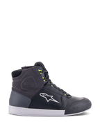 Alpinestars Chrome Drystar Shoes, miejskie sneakersy motocyklowe w kolorze czarnym, ciemnoszarym i żółtym fluo, wykonane z wysokiej jakości skóry i zamszu, biała podeszwa, neonowe żółte sznurowadła i charakterystyczne logo gwiazdy.