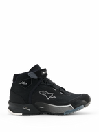 Damskie buty motocyklowe Alpinestars CR-X Drystar, czarne wysokie sneakersy motocyklowe, widok z boku damskiego obuwia do jazdy miejskiej ze sznurowaniem i paskiem na rzep na kostce, białe logo gwiazdy Alpinestars, oznaczenia „Drystar” i „TPF” na podeszwie środkowej, wytrzymała gumowa podeszwa z białymi i szarymi wzorami.
