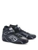Buty Alpinestars Tech-1 T V3 FIA, buty do wyścigów samochodowych, czarno-srebrne, wykonane ze skóry bydlęcej ze srebrnym logo i oznaczeniami Alpinestars, widok z boku pod kątem z zapięciem na rzep i sznurowadłami