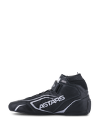 Alpinestars Tech-1 T V3 Shoes FIA, buty wyścigowe, czarno-srebrne, widok z boku, konstrukcja z pełnej skóry bydlęcej ze srebrnym logo ASTARS, regulowany pasek na rzep i elastyczny kołnierz ognioodporny.