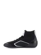 Buty Alpinestars Supertech, buty samochodowe, czarne, widok z profilu z dzianinową cholewką, karbonową osłoną pięty i białymi geometrycznymi akcentami, profesjonalne obuwie motorsportowe