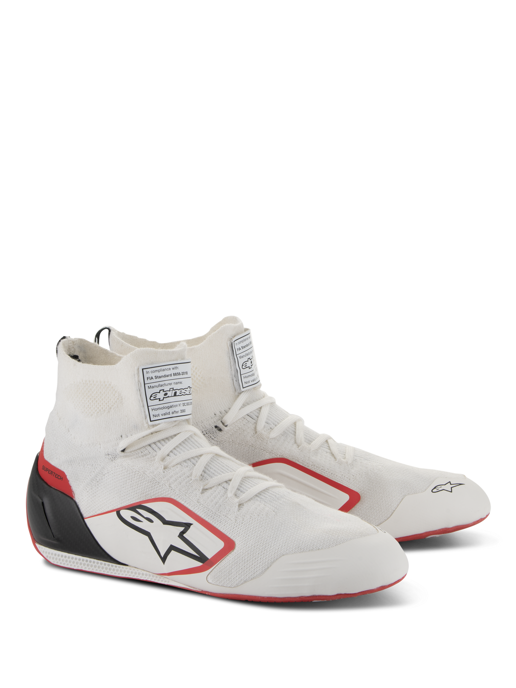 Buty Alpinestars Supertech, obuwie wyścigowe, biało-czerwono-czarne, z w pełni dzianą cholewką, czarnym zapiętkiem z włókna węglowego i czerwonymi akcentami na podeszwie i logo, profesjonalne buty motorsportowe z etykietami certyfikacji FIA/SFI na języku.