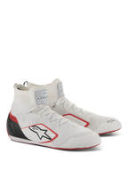 Buty Alpinestars Supertech, obuwie wyścigowe, biało-czerwono-czarne, z w pełni dzianą cholewką, czarnym zapiętkiem z włókna węglowego i czerwonymi akcentami na podeszwie i logo, profesjonalne buty motorsportowe z etykietami certyfikacji FIA/SFI na języku.