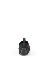 Buty Alpinestars Tech Gaming, czarne, widok od tyłu przedstawiający bezszwową dzianinową cholewkę, teksturowaną gumową piętę z logo gwiazdy i tylny uchwyt z czerwonym brandingiem, obuwie do SIM-racingu