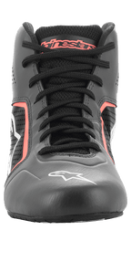 Buty Alpinestars Tech-1 K Start V2, buty kartingowe, kolor Asphalt Black i Orange Fluo, widok z przodu pokazujący czarne sznurowadła, pomarańczowe logo Alpinestars na języku, białe logo gwiazdy na czubku i perforowane panele z mikrofibry