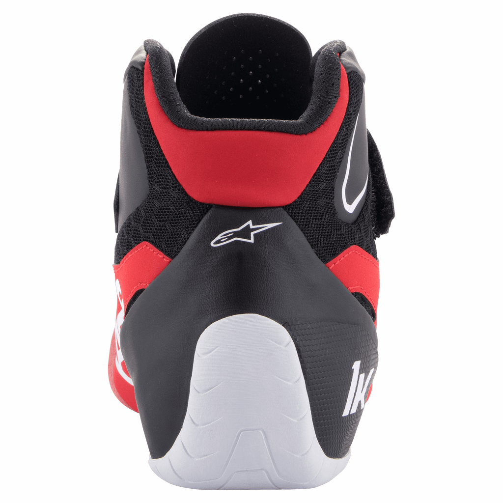 Buty Alpinestars Tech-1 K V2, buty kartingowe, czerwono-czarno-białe, widok z tyłu pokazujący nisko wycięty kołnierz Achillesa, białe wzmocnienie pięty z logo „1K” oraz logo gwiazdy Alpinestars na czarnej cholewce