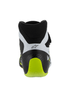 Buty Alpinestars Tech-1 KX V3, buty kartingowe z certyfikatem FIA, czarno-białe i żółte fluo, widok z tyłu ukazujący wzmocnioną jednoczęściową piętę, jaskrawy akcent w kolorze żółtym fluo, białe panele z czarnym logo, techniczne obuwie motorsportowe do użytku na torze