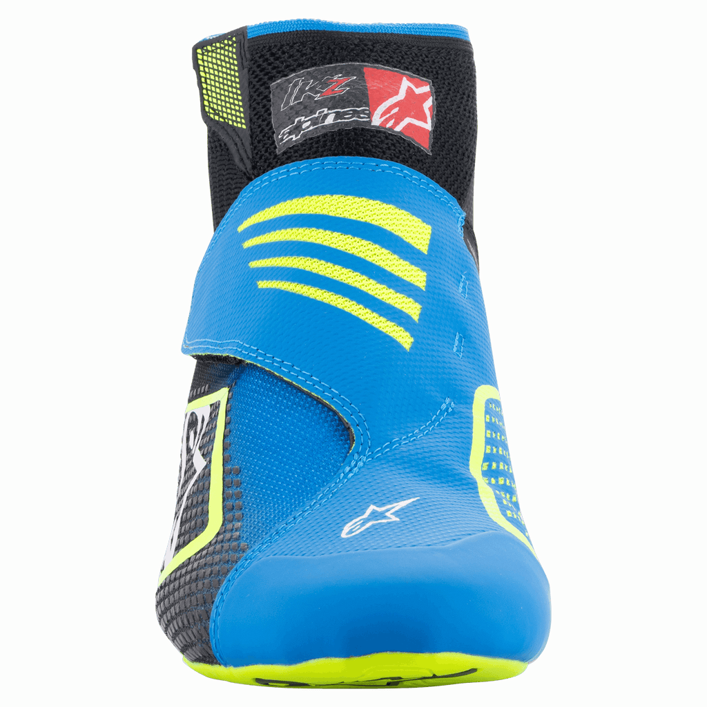 Alpinestars Tech-1 KZ V2 Shoes, buty kartingowe, kolor czarny, błękitny i żółty fluo, widok z przodu ukazujący bezszwową dzianą cholewkę, intensywnie niebieski pasek z żółtymi akcentami i czarny kołnierz wokół kostki