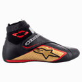 Alpinestars Supermono V2 Shoes FIA, buty wyścigowe, czarne ze złotymi i czerwonymi detalami, widok z boku prezentujący skórzaną konstrukcję z perforowanymi panelami, duże złote logo gwiazdy, elastyczny ognioodporny kołnierz typu skarpetka oraz zapięcie na rzep
