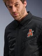 Kurtka Alpinestars Ignite Air, czarna, z tradycyjnym kołnierzykiem koszulowym i oddychającą siatkową konstrukcją, z czerwono-złotą naszywką z logo „A” na piersi, prezentowana na modelu, miejska odzież motocyklowa