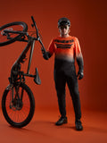 Koszulka A-Dura ASTARS 2.0 z długim rękawem, pomarańczowo-czarny gradient, logo na piersi i pełny sprzęt MTB.