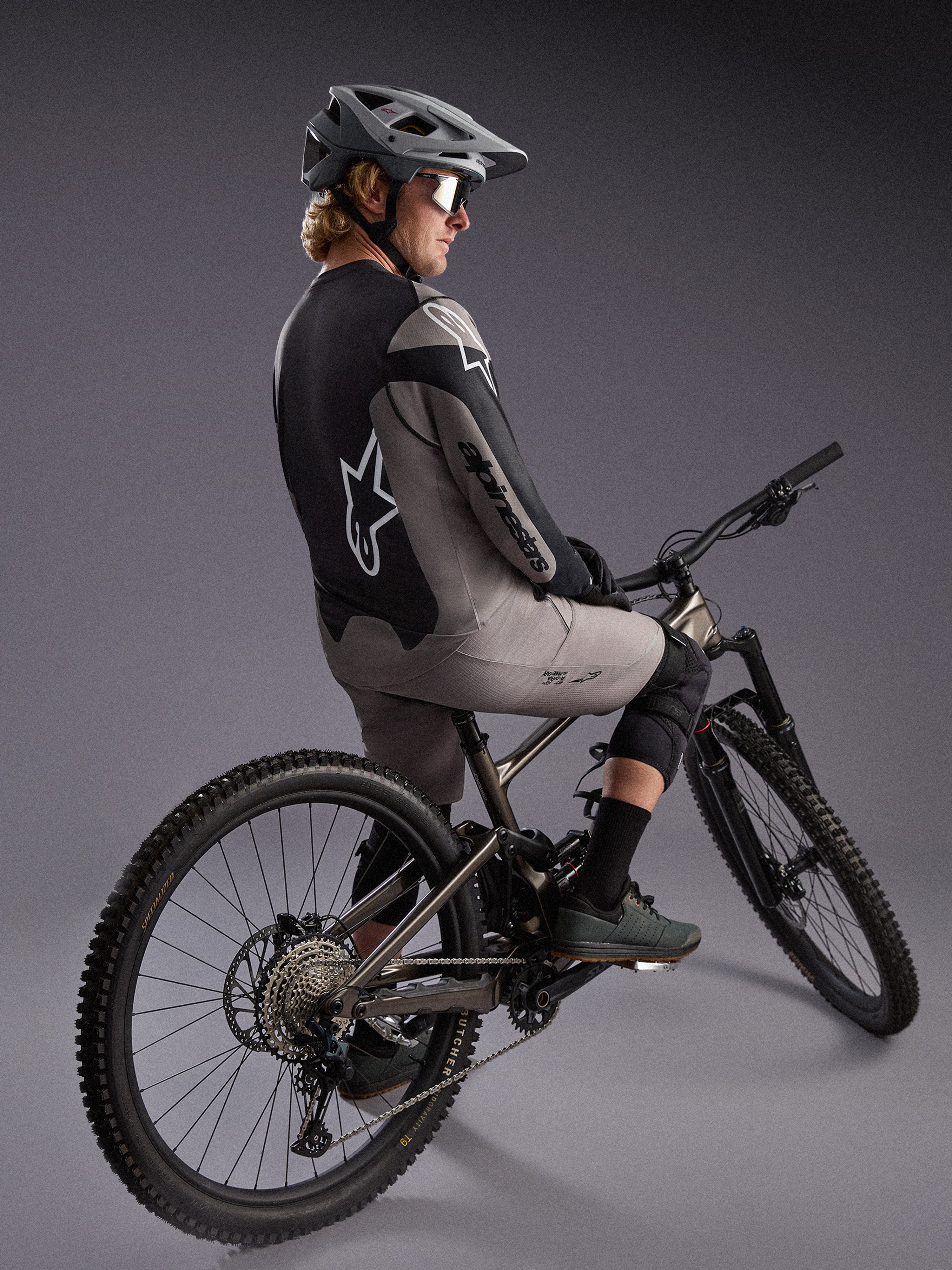 Szara koszulka A-Dura Race z długim rękawem na rowerzyście MTB, z logo Alpinestars i elastycznej tkaniny.