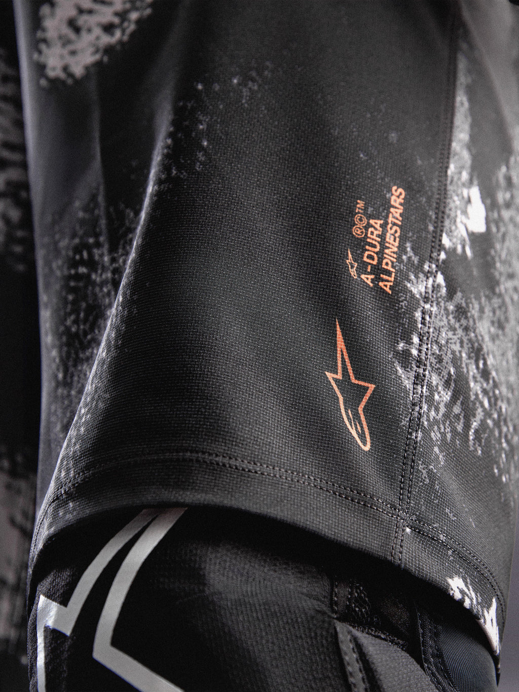 Szorty A-Dura Ride Black Camo, pomarańczowe logo Alpinestars na wytrzymałej tkaninie 4-way stretch do MTB.