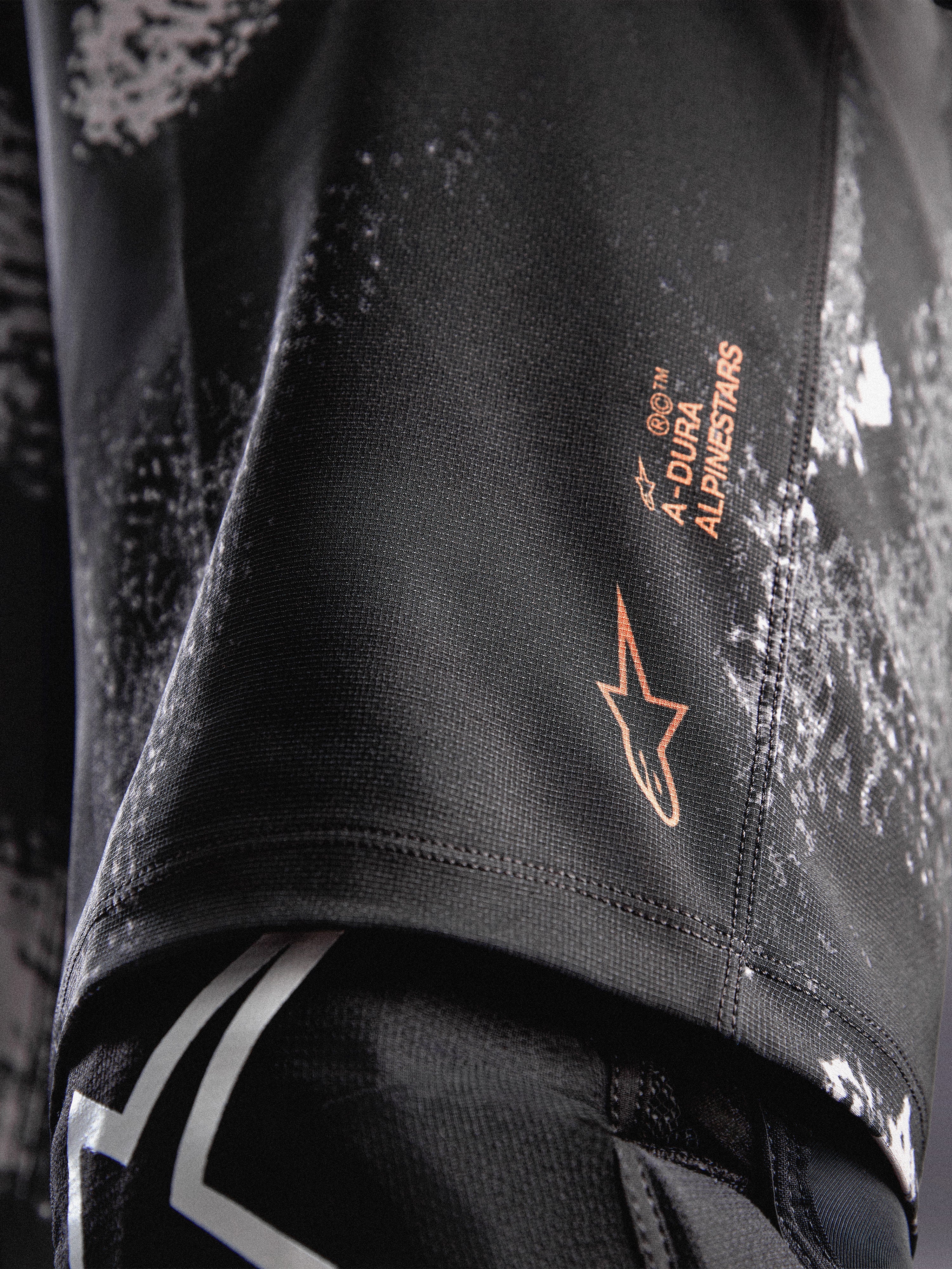Szorty A-Dura Ride Black Camo, pomarańczowe logo Alpinestars na wytrzymałej tkaninie 4-way stretch do MTB.