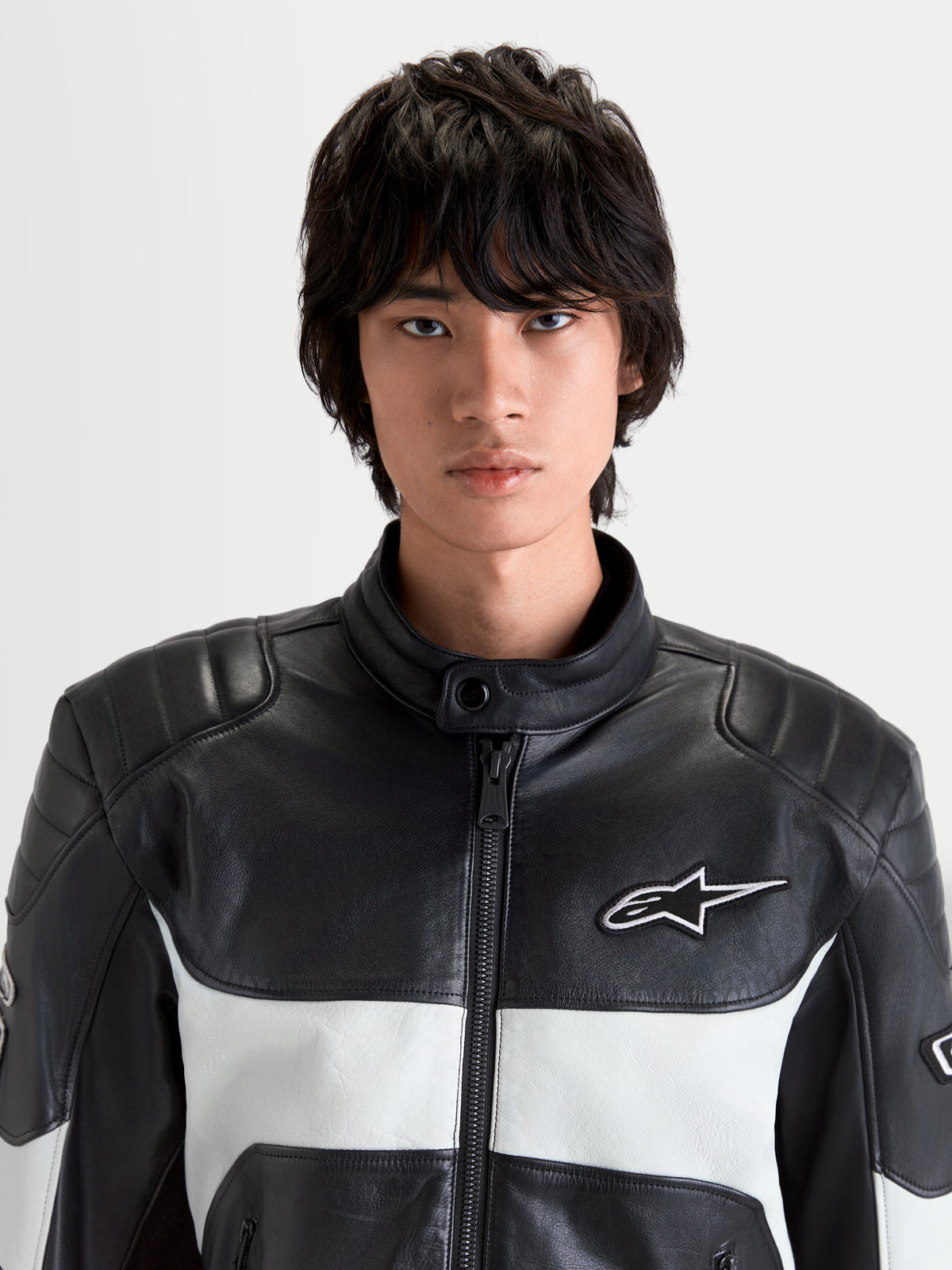 Alpinestars Revern kurtka skórzana męska motocyklowa w kolorze czarnym i szarym, widok z przodu na model prezentujący konstrukcję ze skóry licowej, kołnierz motocyklowy i białe logo Alpinestars