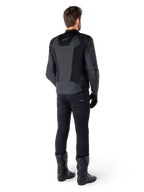 Rear view of a man wearing the Alpinestars Missile V3 Airflow Leather Jacket in Black, featuring extensive perforated panels for ventilation, paired with black riding pants and boots, showcasing a streamlined racing aesthetic.