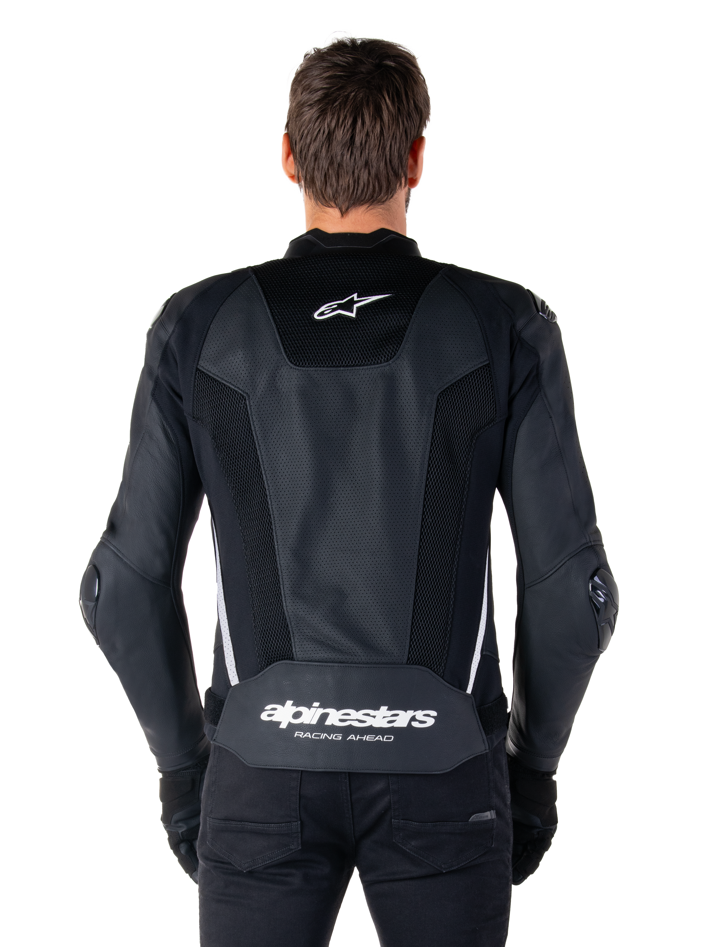 Alpinestars Missile V3 Airflow Leather Jacket, Black and White, back view worn by a rider, featuring extensive perforated leather panels, white side accents, Alpinestars star logo on the upper back, and 'alpinestars RACING AHEAD' branding on the lower back.