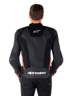 Alpinestars Missile V3 Airflow Leather Jacket w kolorze Black White Red Fluo, widok z tyłu, rozległe perforowane panele skórzane zapewniające wentylację, małe logo Alpinestars w górnej części pleców, wyraźny napis „alpinestars RACING AHEAD” w dolnej części pasa.
