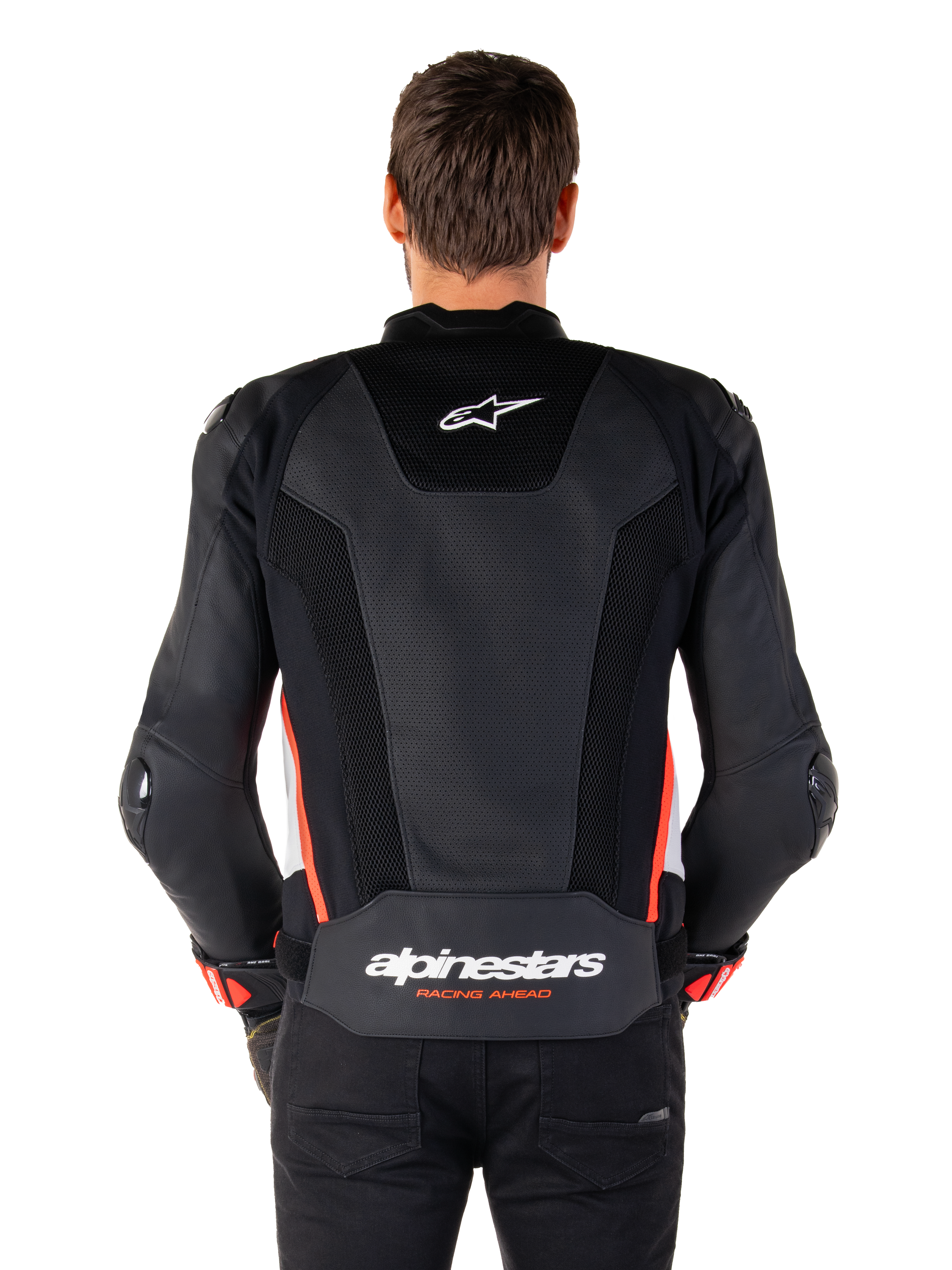 Alpinestars Missile V3 Airflow Leather Jacket w kolorze Black White Red Fluo, widok z tyłu, rozległe perforowane panele skórzane zapewniające wentylację, małe logo Alpinestars w górnej części pleców, wyraźny napis „alpinestars RACING AHEAD” w dolnej części pasa.