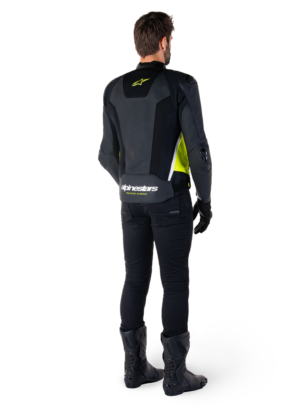 Skórzana kurtka Alpinestars Missile V3 Airflow, czarno-żółta fluo-biała, widok z tyłu na motocykliście, perforowane skórzane panele na plecach, żółte logo Alpinestars, białe akcenty, czarne spodnie i buty motocyklowe
