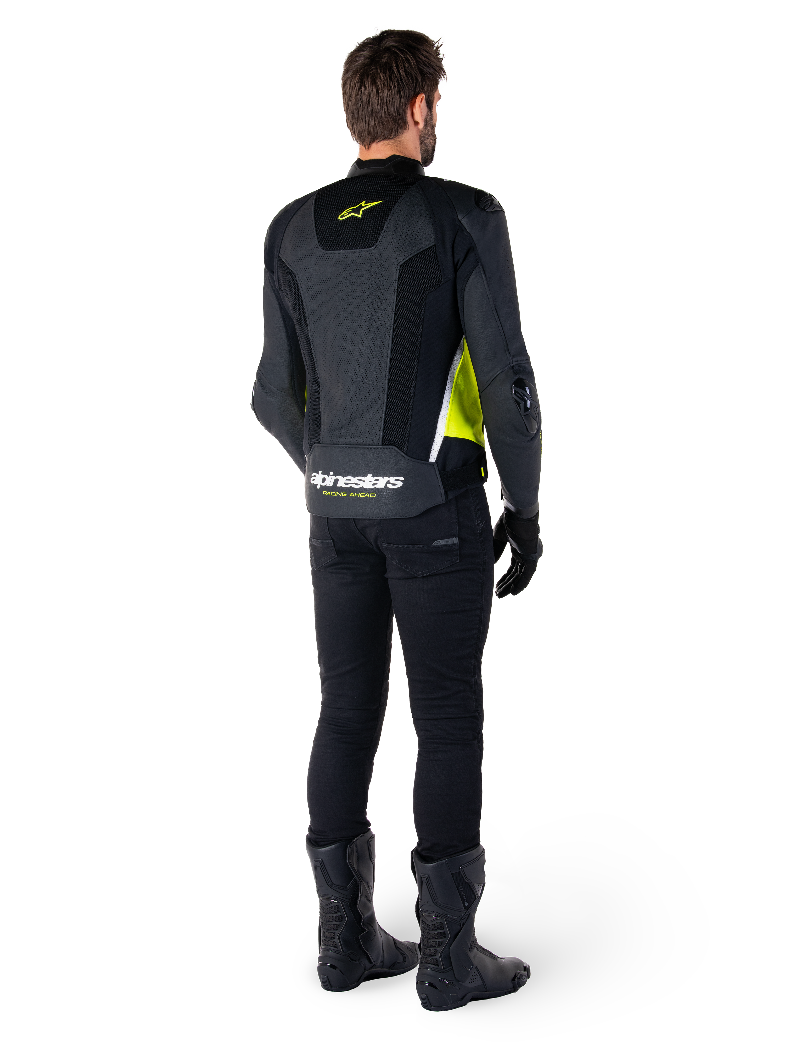 Skórzana kurtka Alpinestars Missile V3 Airflow, czarno-żółta fluo-biała, widok z tyłu na motocykliście, perforowane skórzane panele na plecach, żółte logo Alpinestars, białe akcenty, czarne spodnie i buty motocyklowe