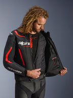 Alpinestars GP Force V2 Leather Jacket, czarno-czerwona fluo, szczegółowy widok wnętrza na modelu prezentujący wypinaną kamizelkę termiczną i wodoodporną kieszeń wewnętrzną, konstrukcja z wysokiej jakości skóry dla ochrony sportowej