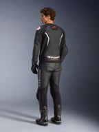 Alpinestars GP Force V2 Air Leather Jacket, czarno-biała, widok z tyłu na modelu z perforowanym panelem tylnym dla wentylacji, białe logo i czerwona gwiazda, noszona z pasującymi skórzanymi spodniami wyścigowymi, rękawicami i butami