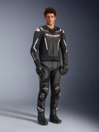 Kurtka skórzana Alpinestars GP Force V2 Air w kolorze czarno-białym, prezentowana przez motocyklistę z dopasowanymi czarnymi spodniami wyścigowymi, rękawicami i butami, wyposażona w perforowane panele skórzane, białe akcenty i czerwone logo Alpinestars na klatce piersiowej, sportowa odzież motocyklowa