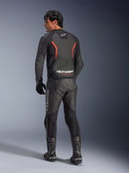 Widok z tyłu modelu ubranego w skórzaną kurtkę Alpinestars GP Force V2 Air w kolorze Black Red Fluo, z perforowanymi panelami skórzanymi i wyraźnym brandingiem Alpinestars w dolnej części pleców, zestawioną z pasującymi czarnymi skórzanymi spodniami i butami motocyklowymi.