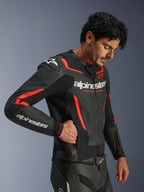 Alpinestars GP Force V2 Air Leather Jacket, czarno-czerwona (Fluo), perforowana skórzana kurtka motocyklowa, model w kurtce sięgający do bocznej kieszeni zapinanej na zamek, z fluorescencyjnymi czerwonymi akcentami i białym logo Alpinestars, profesjonalna sportowa odzież motocyklowa.