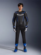 Skórzana kurtka Alpinestars GP Force V2 Airflow w kolorze Black Metallic Blue, noszona z pasującymi rękawicami wyścigowymi, czarnymi spodniami i niebieskimi butami, profesjonalny sportowy zestaw motocyklowy, zdjęcie studyjne całej sylwetki