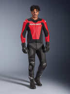 Kurtka skórzana Alpinestars GP Force V2 Air, czerwono-czarna, perforowana skóra z białym logo, noszona przez modela z czarnymi skórzanymi spodniami wyścigowymi i rękawicami, profesjonalny sprzęt motocyklowy