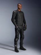 Męski model mający na sobie skórzane spodnie Alpinestars Missile V3 i pasującą czarną skórzaną kurtkę ze złotymi akcentami, czarne rękawice wyścigowe GP Pro oraz czarne buty wyścigowe, kompletny motocyklowy strój wyścigowy do użytku drogowego, ujęcie studyjne.