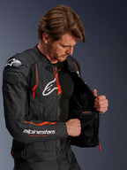 Alpinestars Dusk Airflow Leather Jacket, czarna z neonową czerwienią, na modelu, częściowo rozpięta, aby pokazać wewnętrzną podszewkę z siatki i wodoodporną kieszeń, z perforowaną skórą dla wentylacji oraz wyraźnym logo na klatce piersiowej i rękawie.