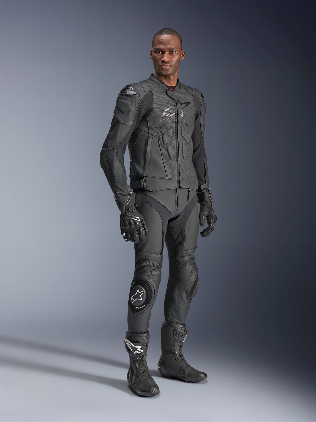 Skórzana kurtka Alpinestars Dusk Airflow, Black Black, motocyklista w pełnym rynsztunku technicznym ze skórzanymi spodniami, rękawicami i butami, perforowane panele skórzane dla wentylacji, zintegrowane ochraniacze do sportowej jazdy motocyklowej