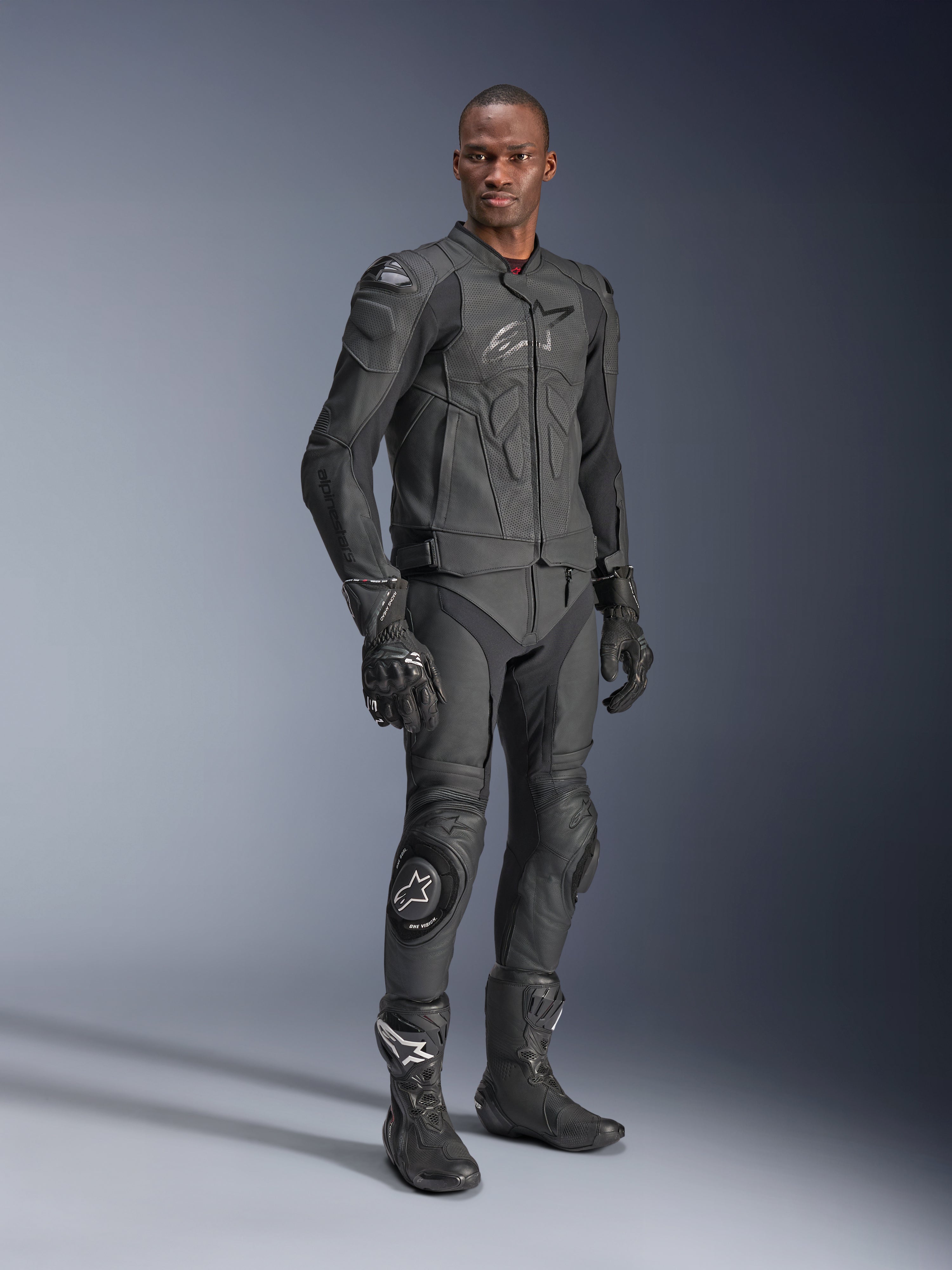 Skórzana kurtka Alpinestars Dusk Airflow, Black Black, motocyklista w pełnym rynsztunku technicznym ze skórzanymi spodniami, rękawicami i butami, perforowane panele skórzane dla wentylacji, zintegrowane ochraniacze do sportowej jazdy motocyklowej