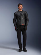 Skórzana kurtka Alpinestars GP Plus R V4 Airflow, czarna, noszona przez modela z pasującymi czarnymi rękawicami i spodniami, z perforowanymi panelami skórzanymi, dużym stonowanym logo z gwiazdą na klatce piersiowej i dopasowanym sportowym krojem